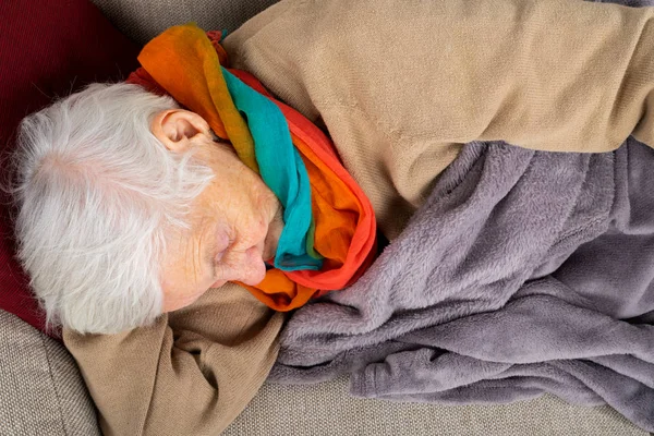 Vecchia signora sdraiata sul divano — Foto Stock