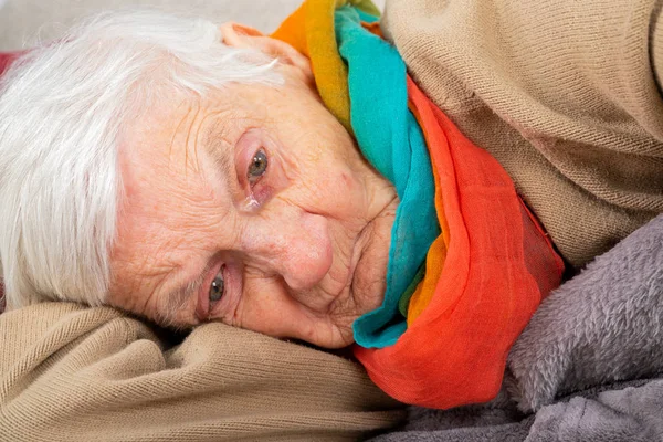 Old lady lying on the couch — Stock Photo, Image