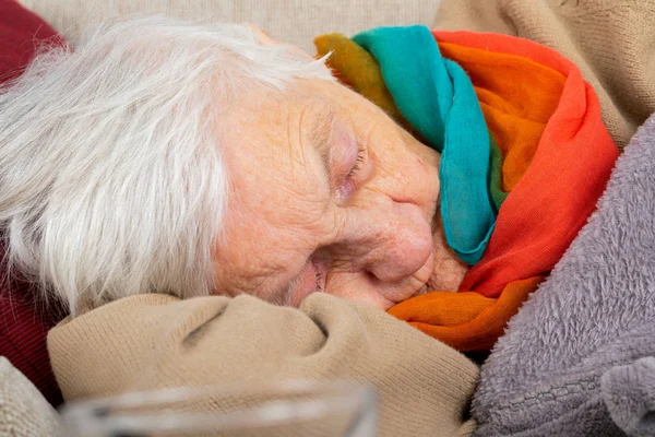 Alte Dame auf dem Sofa liegend — Stockfoto