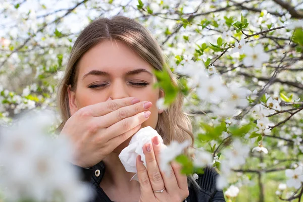 Mulher alérgica espirrando ao ar livre na primavera — Fotografia de Stock