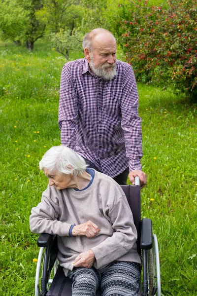 Old lady with dementia in a wheelchair and carer — Stock Photo, Image