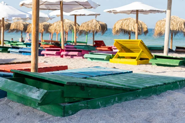 Lettini e ombrelloni colorati in spiaggia — Foto Stock