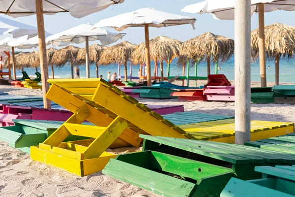 Lettini e ombrelloni colorati in spiaggia — Foto Stock