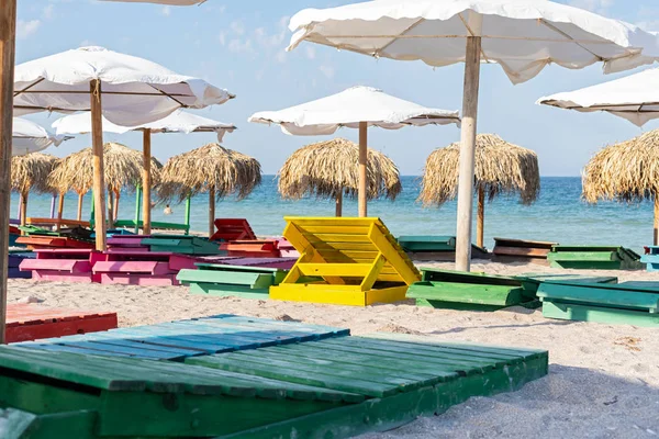 Lettini e ombrelloni colorati in spiaggia — Foto Stock