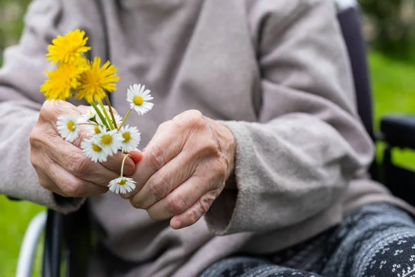 花を持った高齢者の握手 — ストック写真