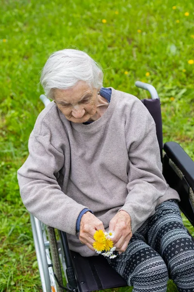 Femme âgée en fauteuil roulant avec assistance médicale — Photo