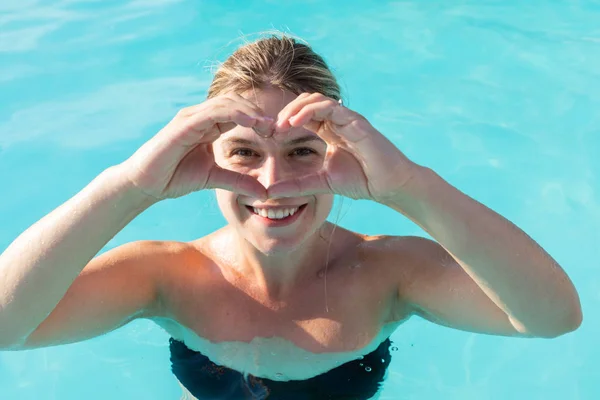 Mulher na piscina, símbolo do coração — Fotografia de Stock