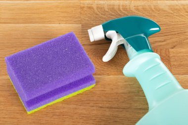 Ahşap arka planda renkli temizlik malzemeleri ve araçlarının resmi