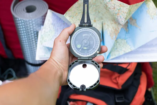 Picture of camping tools on the grass - backpack, tent, gas tank, cans, compass, etc - ready to go in the woods