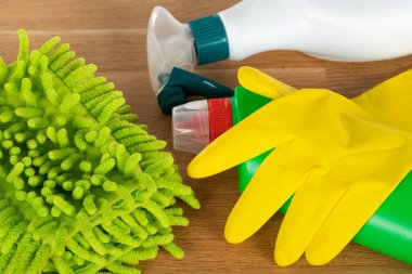 Ahşap arka planda renkli temizlik malzemelerinin resmi