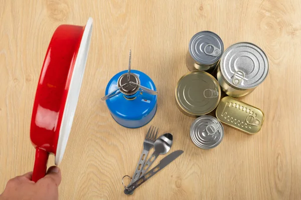 Picture of camping tools on a table -  gas tank, cans, etc - ready to go in the woods