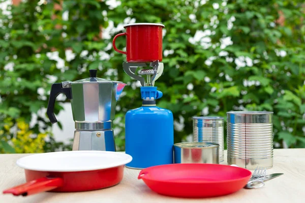 Picture of camping tools on a table -  gas tank, cans, etc - ready to go in the woods