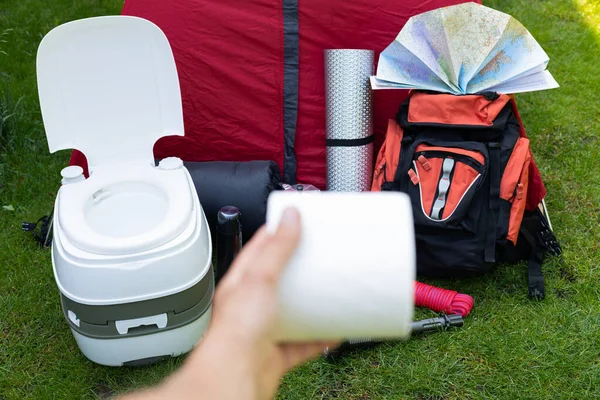 Picture of camping tools on the grass - backpack, tent, gas tank, cans, compass, etc - ready to go in the woods