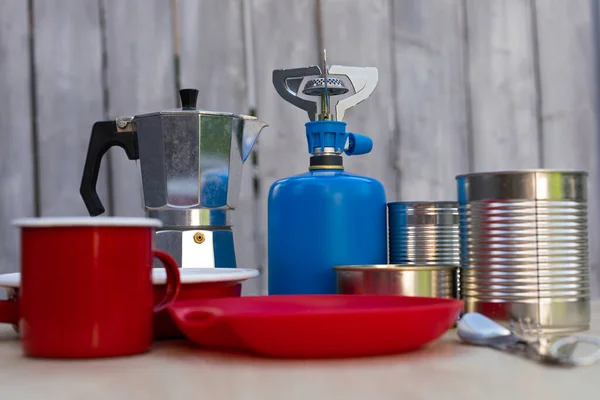 Picture of camping tools on a table -  gas tank, cans, etc - ready to go in the woods