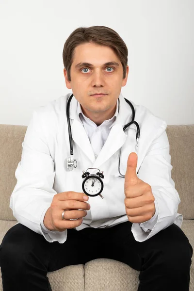 Άντρας Γιατρός Κρατώντας Ένα Μαύρο Ρολόι Στα Χέρια Του — Φωτογραφία Αρχείου