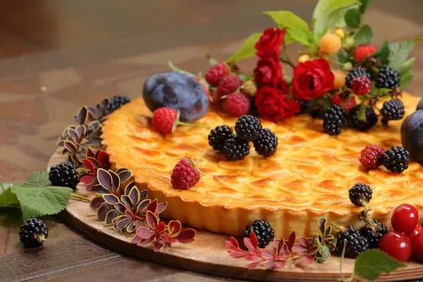 summer cake with prunes and berries on a tray close-up