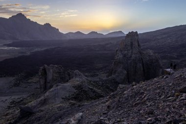 bir yanardağ eteklerinde, dağlarda günbatımı