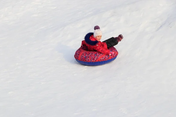 Mädchen Auf Einem Aufblasbaren Schlitten Fährt Von Einem Schneebedeckten Hang — Stockfoto