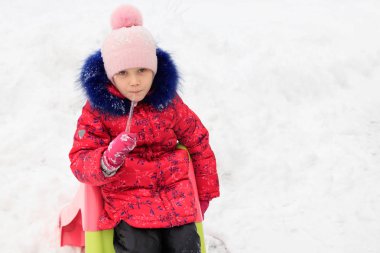 bir kız ile bir buz saçağı kışın karda oynuyor