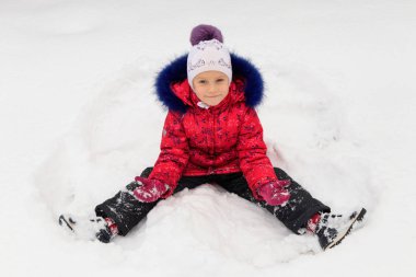 bir kız kışın karda oynuyor