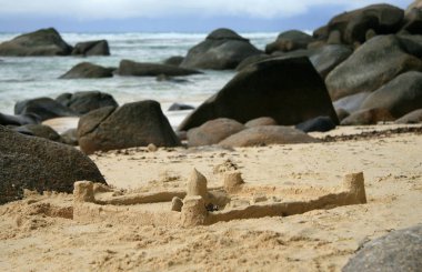 kayalar arasında sahilde kum kale