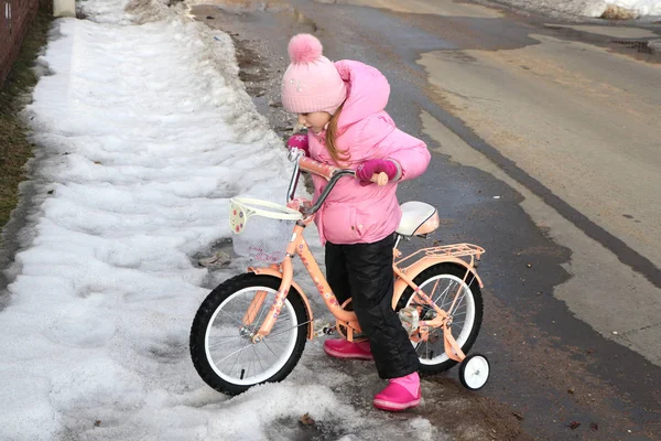 Menina Uma Jaqueta Rosa Uma Bicicleta Primavera Chama Neve Derretida — Fotografia de Stock