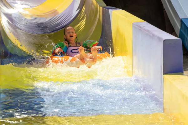 the girl moves down from the water slide on the water tubing