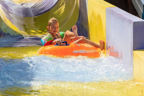 the girl moves down from the water slide on the water tubing