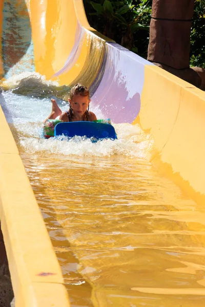 the girl moves down from the water slide on the water tubing