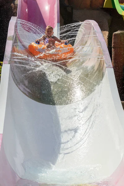 the girl moves down from the water slide on the water tubing