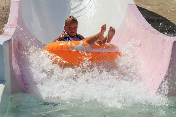 the girl moves down from the water slide on the water tubing