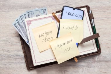 bize dolar ile Organizatör ve açık hesap makinesi numaraları 1 000 000 ve yapışkan notu ile bir yazıt ile işletme planı, ben istiyorum, ben biliyorum ne kadar ben bir masa arka plan üzerinde Can sac