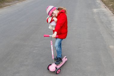 Kız şehir de yol baharda bir scooter sürme