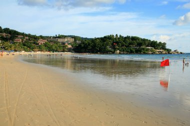düşük tide Kumdaki ve yüzme okyanusta yasaklamaya sinyal bir kırmızı bayrak ile kumlu plaj