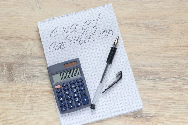 碑文のメモ帳と電卓を開くとテーブルの上のペンの正確な計算 — ストック写真
