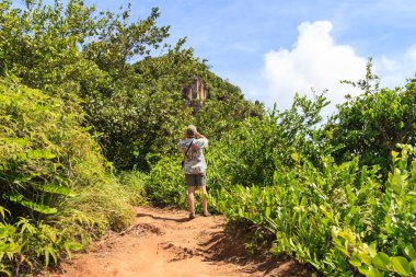 Erkekler tropik bir adada bir görüntüleme platformu üzerinden fotoğraf çekmek için iyi bir açı arıyoruz