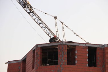 bir perforatör ile inşaat altında bir binanın çatı üzerinde işçi