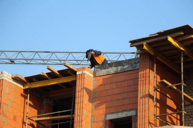bir perforatör ile inşaat altında bir binanın çatı üzerinde işçi