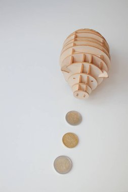 Beyaz arka planda bozuk paraları olan kumbara.