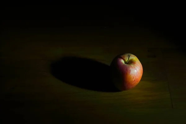 Ένα Κόκκινο Μήλο Πάνω Από Ένα Σκοτεινό Ξύλινο Τραπέζι — Φωτογραφία Αρχείου