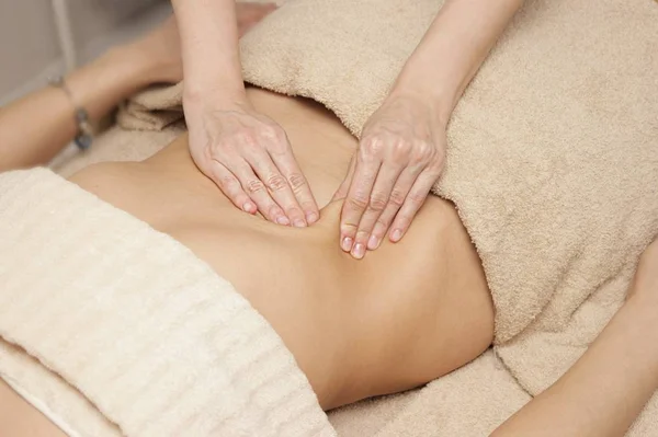 Masajista haciendo masaje terapéutico del abdomen para una mujer — Foto de Stock