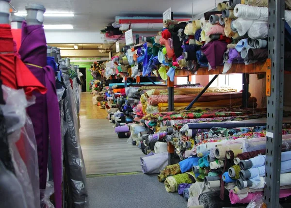 racks with rolls of fabrics in a fabric store