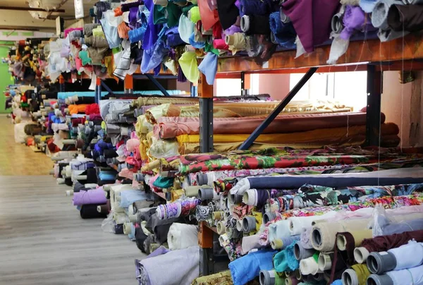 racks with rolls of fabrics in a fabric store