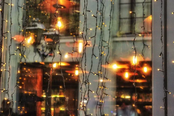 Reflexão de arquitetura, luzes no Natal, janelas de loja de Ano Novo, em janelas, janelas, asfalto molhado — Fotografia de Stock