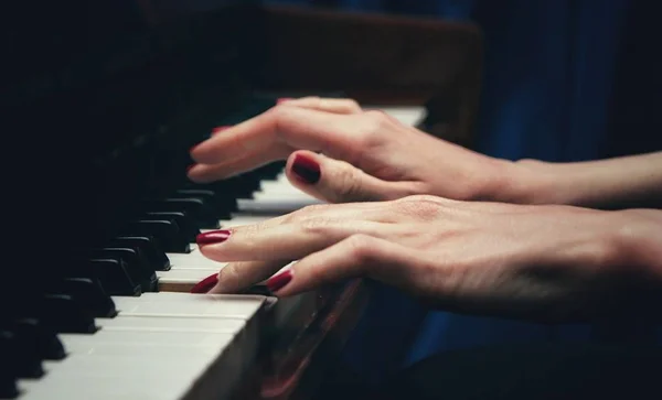 Τα χέρια μιας όμορφης νεαρής γυναίκας που παίζει πιάνο. πλευρική προβολή. επιλεκτική εστίαση. Αντιγράψτε το διαστημικό θόλωμα — Φωτογραφία Αρχείου