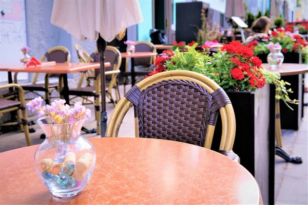 Kwiaty, stoły obiadowe na werandzie ulicy kawiarnia. — Zdjęcie stockowe