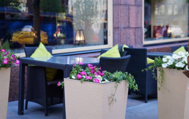 çiçekler, bir sokak kafede verandada yemek masaları. 