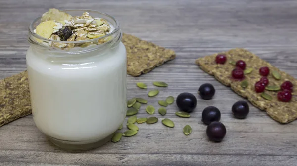 Yunan yoğurt, süt, smoothies, yaban mersini ve kuş üzümü ahşap bir masa üzerinde bir cam kavanoza detoks, diyet