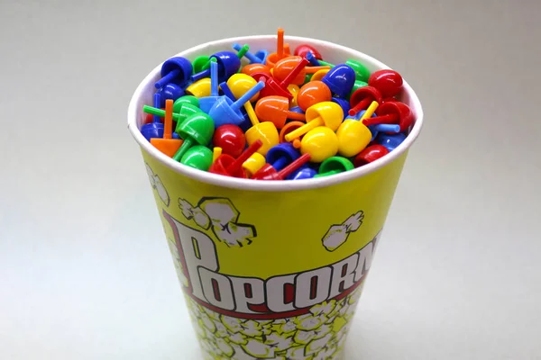 Pequeños juguetes de colores en un cubo de palomitas de maíz — Foto de Stock
