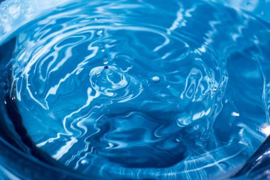 Su dalgalanması arka plan. Bir damla sudan su sıçratıyor. Mavi arka plandaki yağmur damlaları. Suyun dokusu. Aqua, turkuaz, makro